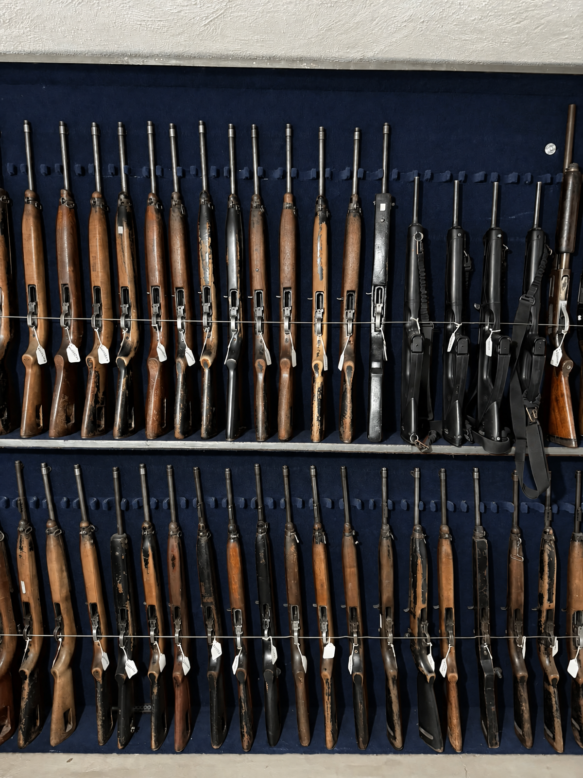 Rack de armamento largo con etiquetas de inventario, resguardado en el armario de la empresa